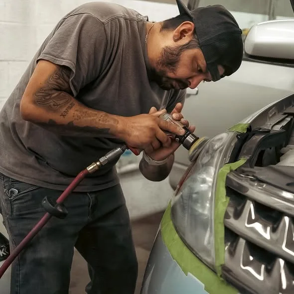 Showtime technician carefully refinishing a headlight