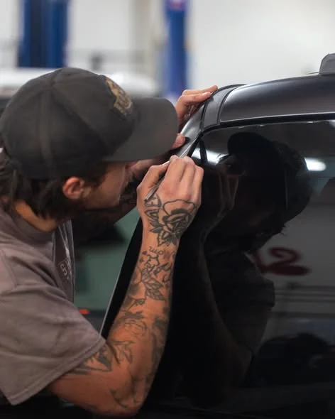 Showtime technician carefully fitting trim to a repaired vehicle